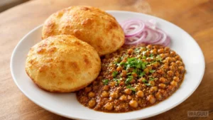 Chole Bhature – kořeněná cizrna v husté omáčce podávaná s velkými nadýchanými smaženými plackami bhature, oblíbená zejména v severní Indii.