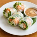 Gỏi Cuốn – frische Sommerrollen aus Reispapier, gefüllt mit Garnelen oder Schweinefleisch, Reisnudeln, Salat und Kräutern, serviert mit Erdnuss- oder Fischsoße.