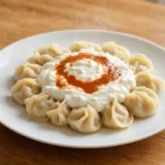 Mantı – Kleine gefüllte Teigtaschen mit Hackfleisch, serviert mit Knoblauchjoghurt und mit Paprika gewürzter Butter.
