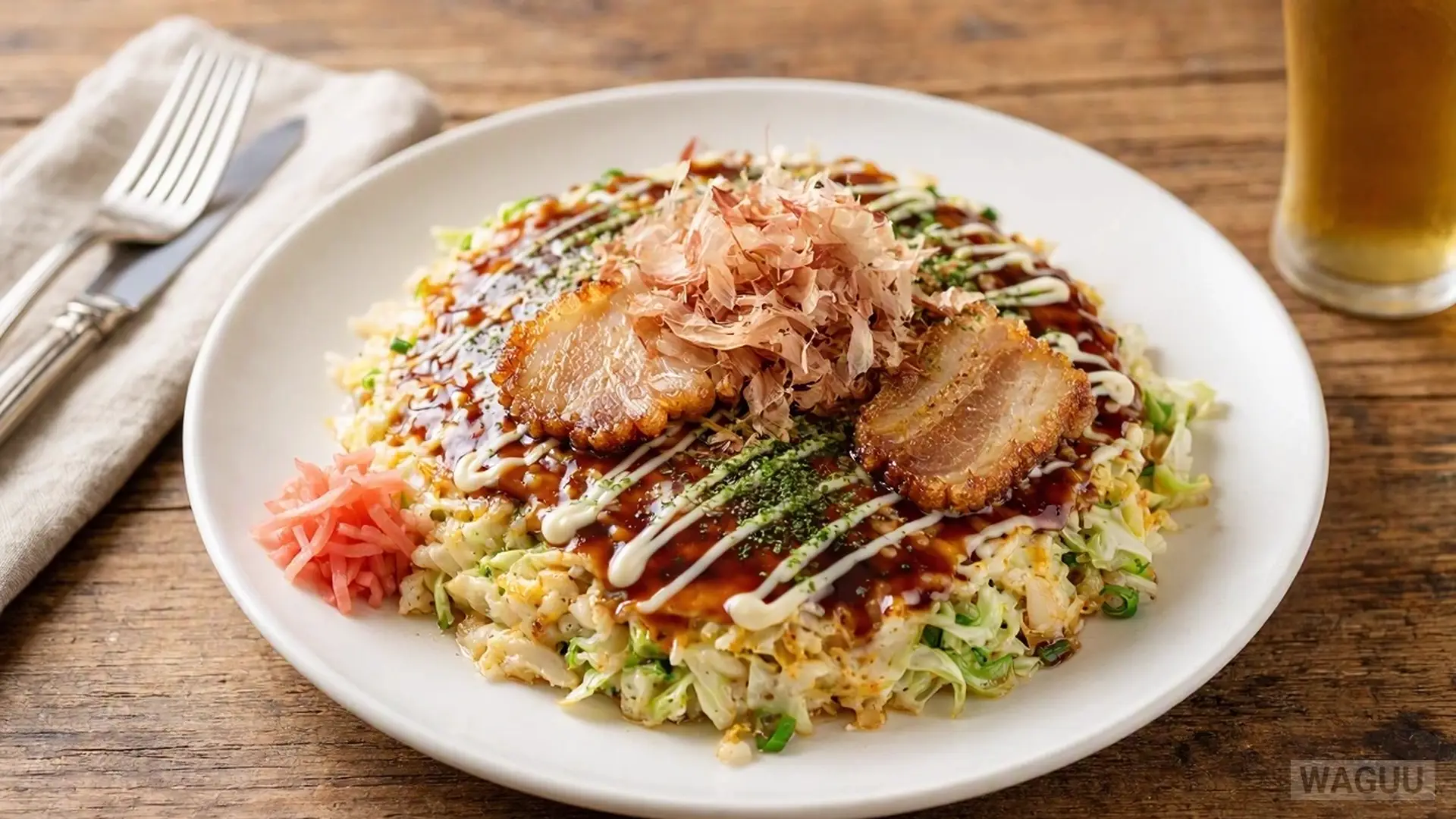 Okonomiyaki – a savory Japanese pancake made of batter, cabbage, and other ingredients, often topped with pork, okonomiyaki sauce, mayonnaise, and bonito flakes.