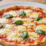 Pizza Margherita – Italská pizza s rajčatovou omáčkou, mozzarellou, bazalkou a olivovým olejem, která vyniká jednoduchostí a kvalitními surovinami.